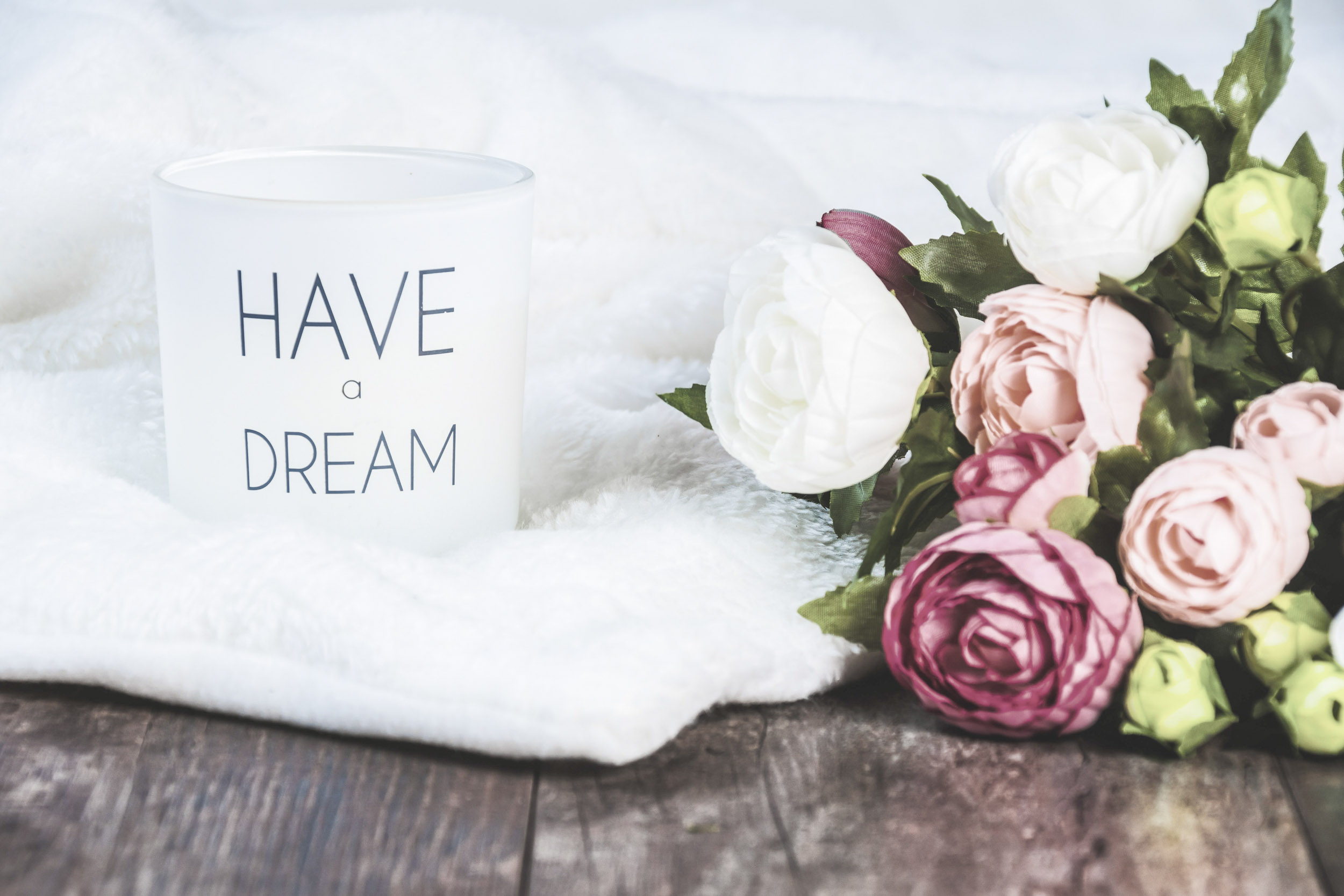 Massage studio towel, candle, and flowers arranged for a calm first massage visit